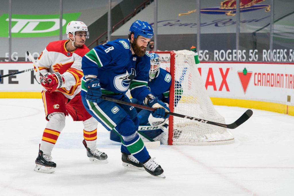 Feb 15, 2021; Vancouver, British Columbia, CAN; Calgary Flames forward Johnny Gaudreau (13) checks Vancouver Canucks defenseman Jordie Benn (8) in the third period period at Rogers Arena. Flames won 4-3 in Overtime. Mandatory Credit: Bob Frid-USA TODAY Sports